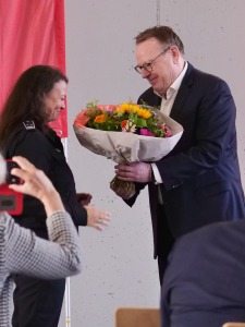 Torsten Burmester überreicht Katja Radnai bei der Einweihung in Rodenkirchen Blumen.
