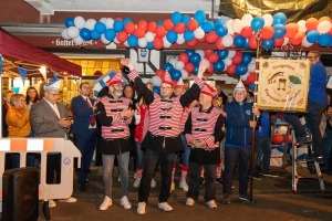 Das designierte Dreigestirn jubelt vor der Gaststätte Alt Weiß in Köln-Weiß unter einem Ballonbogen