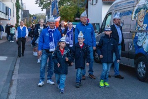 Drei Kinder in Karnevalsmützen führen den Zug der Kapelle Jonge durch Köln-Weiß an